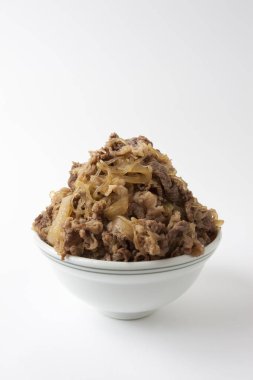 Arkaplanda pilav olan lezzetli et kasesi.