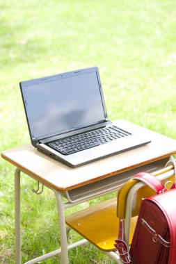 Laptopu yeşil alandaki açık masada kapat.