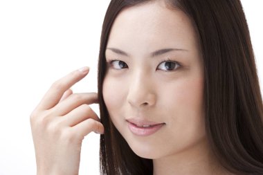 Temiz ciltli genç bir kadın beyaz arka planda izole edilmiş. 