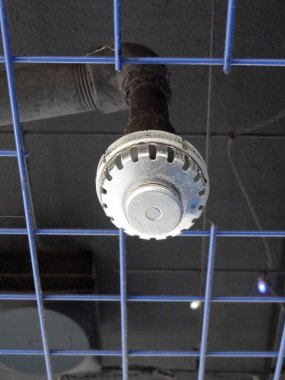 Metal fıskiye başlığı tavan şebekesinden sarkıyor