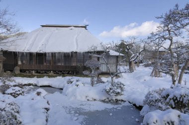 Geleneksel Japon evi karla kaplı bahçeyle çevrili.