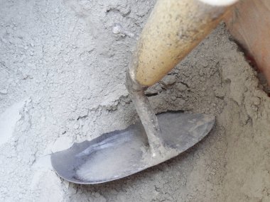 Metal mala kullanarak kuru çimento karıştırılıyor