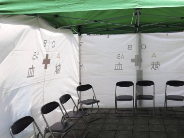 Dışarıdaki tıbbi çadırın içinde boş katlanan sandalyeler.