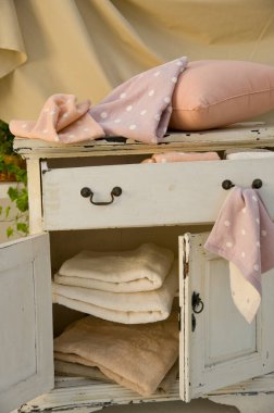 Katlanmış battaniye ve yastıkların sergilendiği eski bir dolap