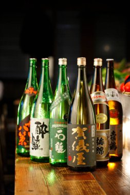 Masada çeşitli sake şişeleri gösteriliyor.