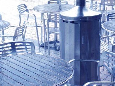 Bir restoran terasında metal masalar ve sandalyeler.