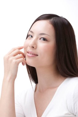 Güzel Asyalı kadın, beyaz arka planda soyutlanmış bir gülümsemesi var. 