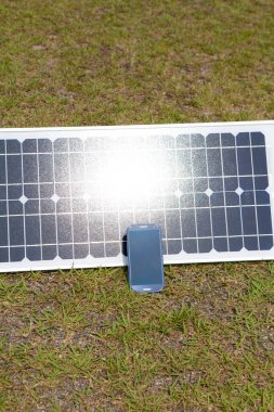 akıllı telefon ve yeşil çimenler üzerindeki güneş paneli