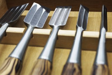 Çekmecede düzgünce düzenlenmiş çeşitli ahşap keskiler.