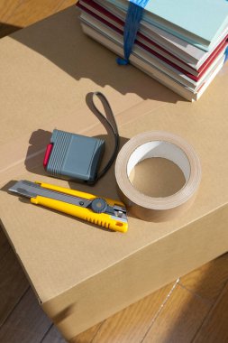 Boş odadaki karton kutudaki araçların yakın görüntüsü. yeni ev kavramı        