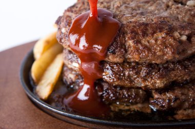 Ketçaplı kızarmış biftek ve patates kızartması.  