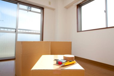 Boş odadaki karton kutudaki araçların yakın görüntüsü. yeni ev kavramı        