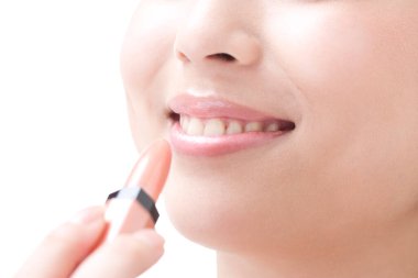 Kozmetik dudak parlatıcısı süren kadın