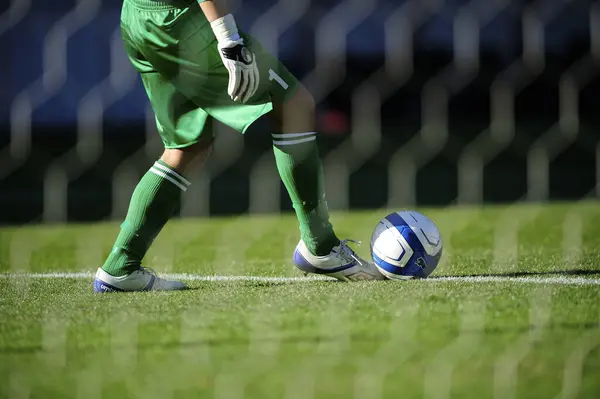 草の上のボールで遊ぶスポーツウェアのサッカー選手の足 — ストック写真