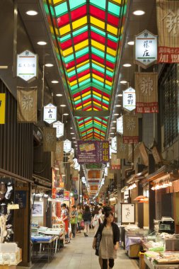 İnsanlar alışveriş alanında sokakta yürüyorlar.