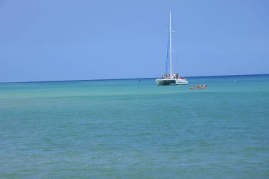 Güneşli bir günde, masmavi denizde beyaz yatın güzel manzarası.
