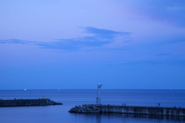 Deniz kıyısında deniz feneriyle güzel gün batımı gökyüzü   