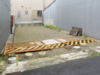 İnşaat bariyeri olan binalar arasında boş çakıl taşı parkı