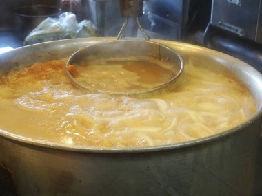 Buharlı tencere çorbada erişte pişiriyor.