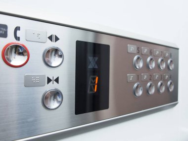 Modern metalik asansör kontrol düğmelerini gösteren yakın çekim