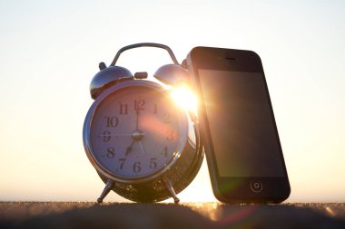 Arka planda alarmlı cep telefonu.