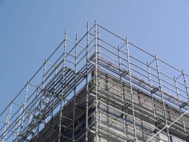 Bir binanın çatısında iskele ve mavi gökyüzü.