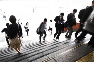 Şehirde merdivenlerden inip çıkan kalabalığın hareketli görüntüsü bulanık.   