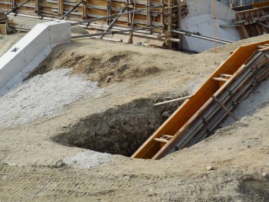 Kazılmış inşaat alanı açık toprak ve ahşap iskelet gösteriyor.