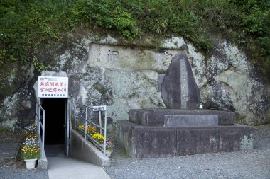 Mağaranın girişindeki taş anıt çiçeklerle çevrili.