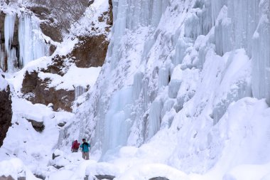Kış ormanlarında şelale ve doğa geçmişi olan insanlar.