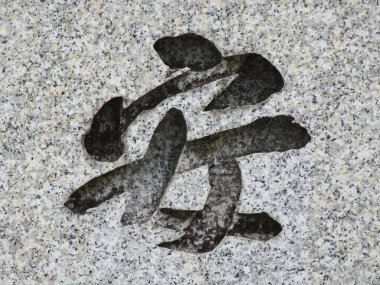 Gri duvarda siyah Japon kaligrafisi