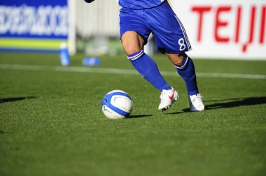 Spor giyim sektöründe futbol oyuncusunun bacakları çimlerin üzerinde top oynuyor.                 