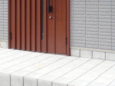 Gri tuğlalı duvarın yanındaki modern ahşap kapı.