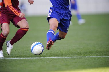 Spor giyim sektöründe futbol oyuncularının bacakları çimlerin üzerinde top oynuyorlar.                 