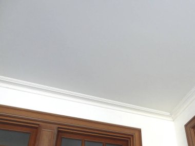 Ahşap süslemeli beyaz tavan ve açık renkli duvarlar