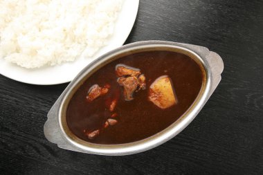 Lezzetli köri ile buğulanmış pilav basit bir yemek ortamında servis edilir.