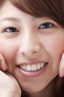 Genç ve güzel Japon kadın gülümsüyor.