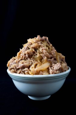 Arkaplanda pilav olan lezzetli et kasesi.