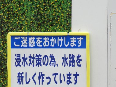 Yeşil yapay koruma arka planına karşı Japonca uyarı işareti