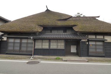 Sazdan çatılı ve ahşap dış duvarlı geleneksel Japon evi.