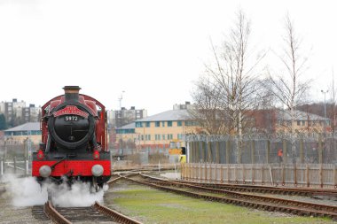 Tren demiryolunda ilerliyor.