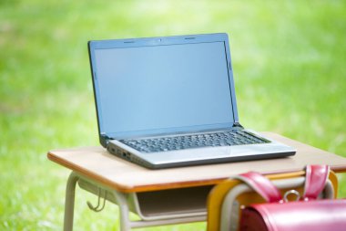 Laptopu yeşil alandaki açık masada kapat.