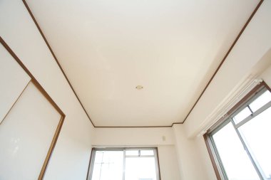 Penceresi ve beyaz tavanı olan bir oda.