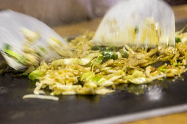 Bir insan masada yemek kesiyor.