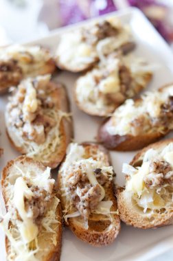 Üzerinde et ve peynir olan bir tabak ekmek.