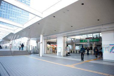 Bir grup insan binanın önünde yürüyor.