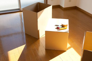 Boş odadaki karton kutudaki araçların yakın görüntüsü. yeni ev kavramı        