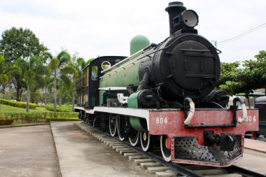 Ağır demiryolu ulaşımı. Güçlü lokomotif trenini güneşli bir Japon şehrinden geçirir..