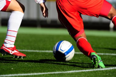 Spor giyim sektöründe futbol oyuncularının bacakları çimlerin üzerinde top oynuyorlar.                 