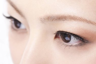 Güzellik kirpikleri makyajlı Asyalı genç bir kadının yakın plan fotoğrafı.